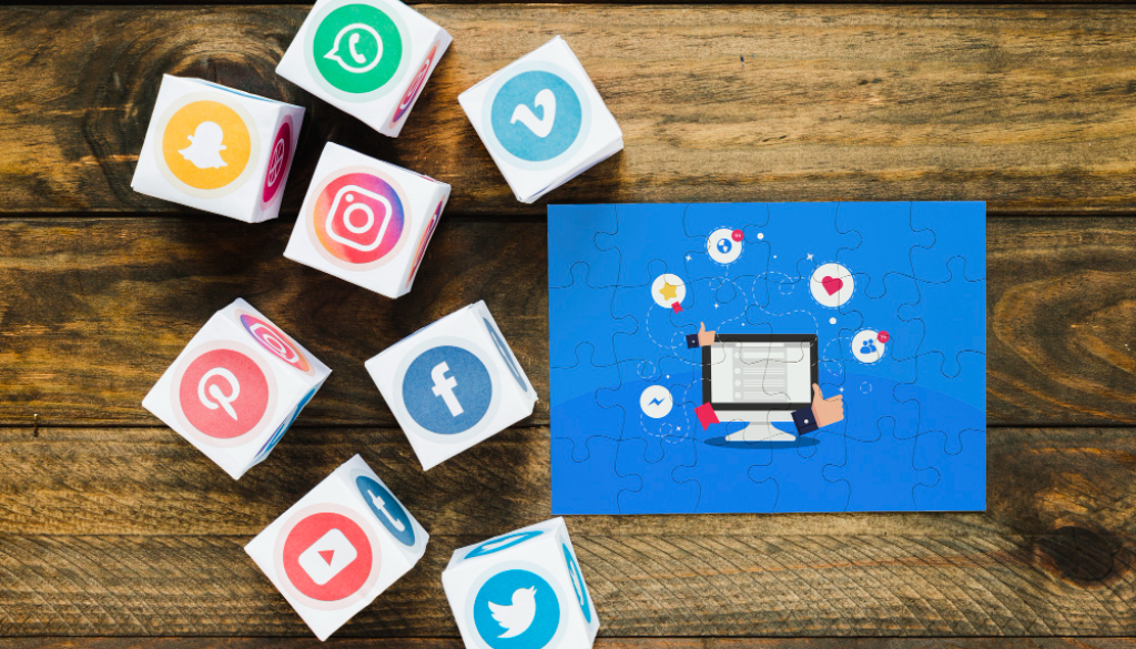 Social media icons on cubes surrounding an Instagram marketing puzzle on a wooden table.