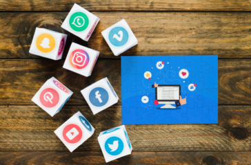 Social media icons on cubes surrounding an Instagram marketing puzzle on a wooden table.