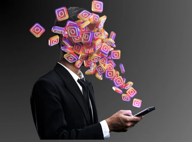 Man in a suit absorbed by a burst of Instagram logos streaming from his smartphone, symbolizing the impact of social media.