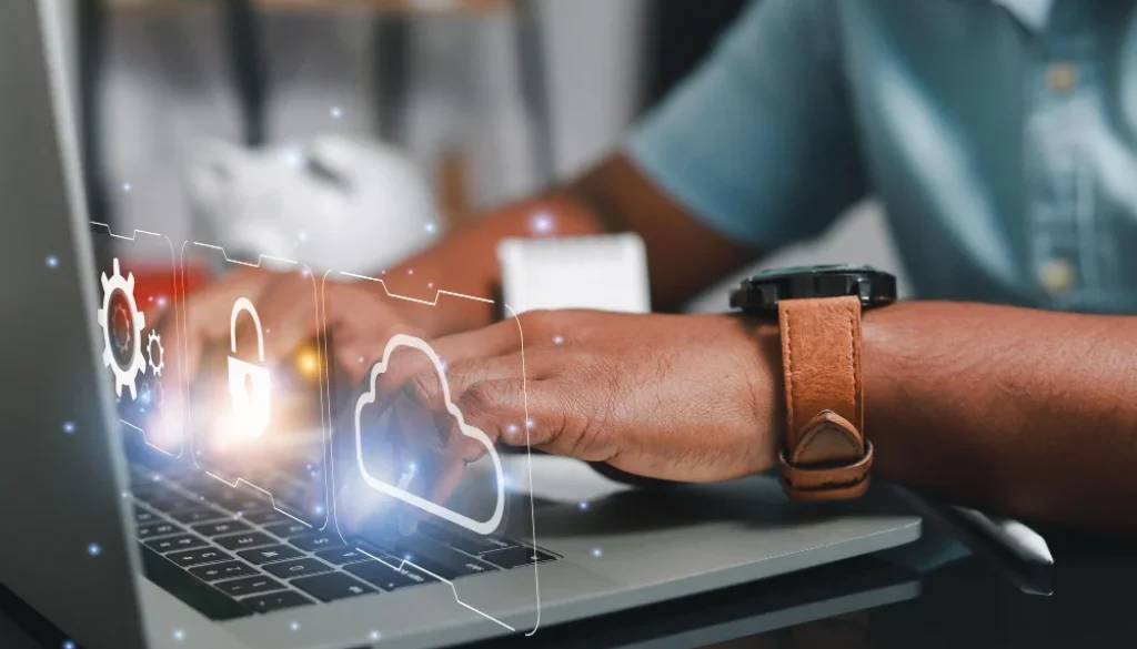 Person working on laptop with hybrid cloud security icons on screen